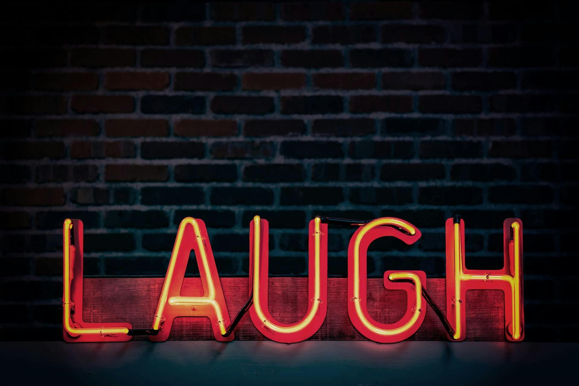 Escrita "laugh" em letra neon (risada em inglês)