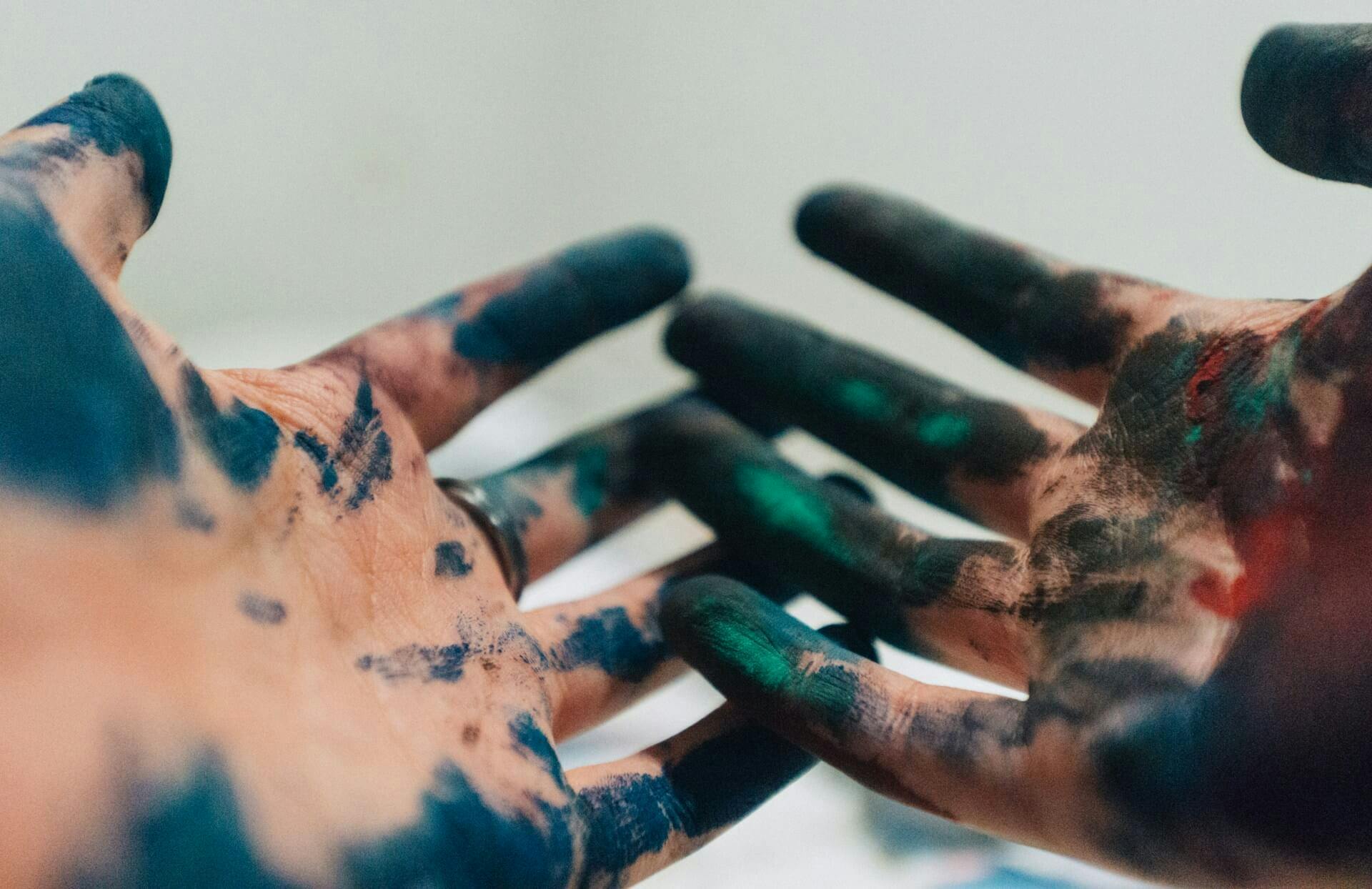 mãos sujas de tinta simbolizando a criação