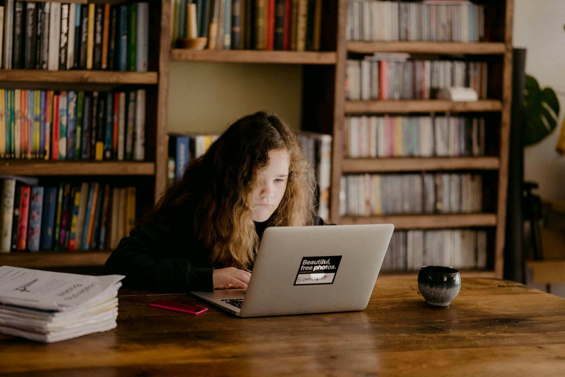 uma menina em frente a um notebook revisando um conteúdo